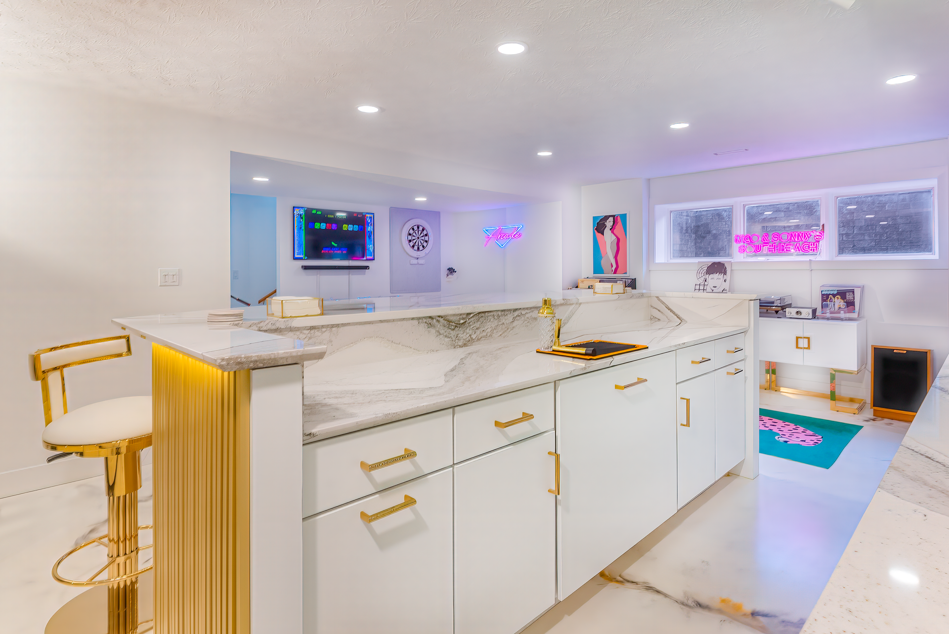 Modern white and gold kitchen with large island and bar seating.
