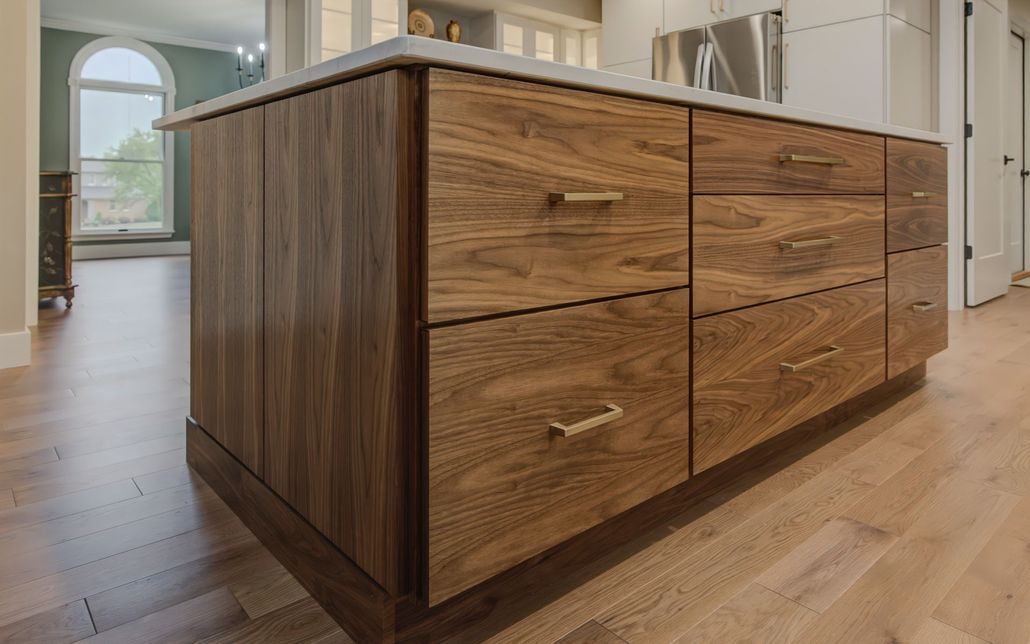 A kitchen island with wooden drawers and a marble counter top.