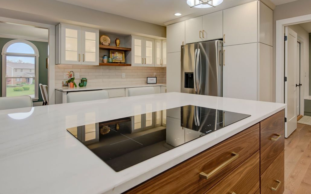 A kitchen with a large island and a stove top oven.