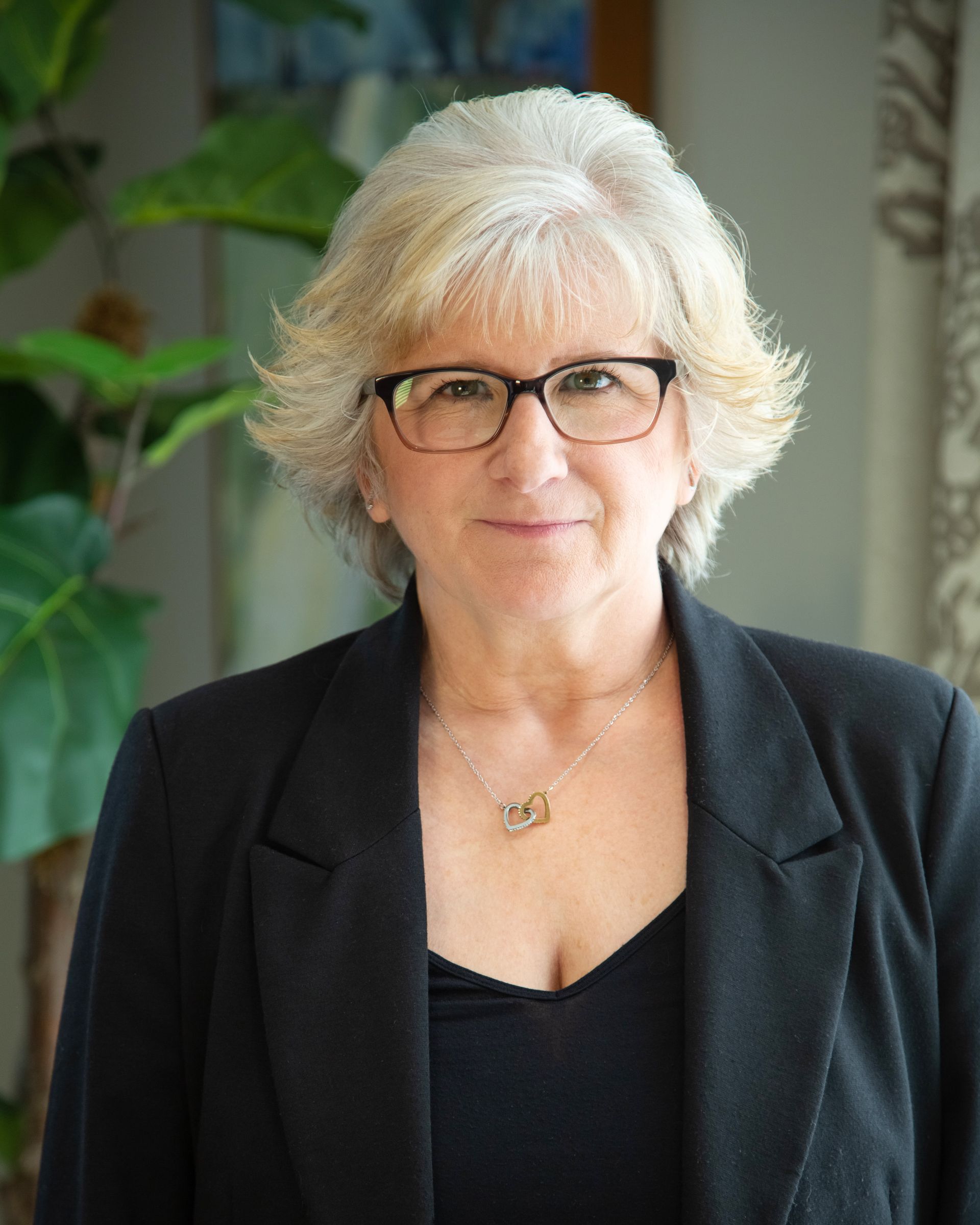 Silhouette of a person, mid-chest up, with shoulder-length hair, against a gray background.
