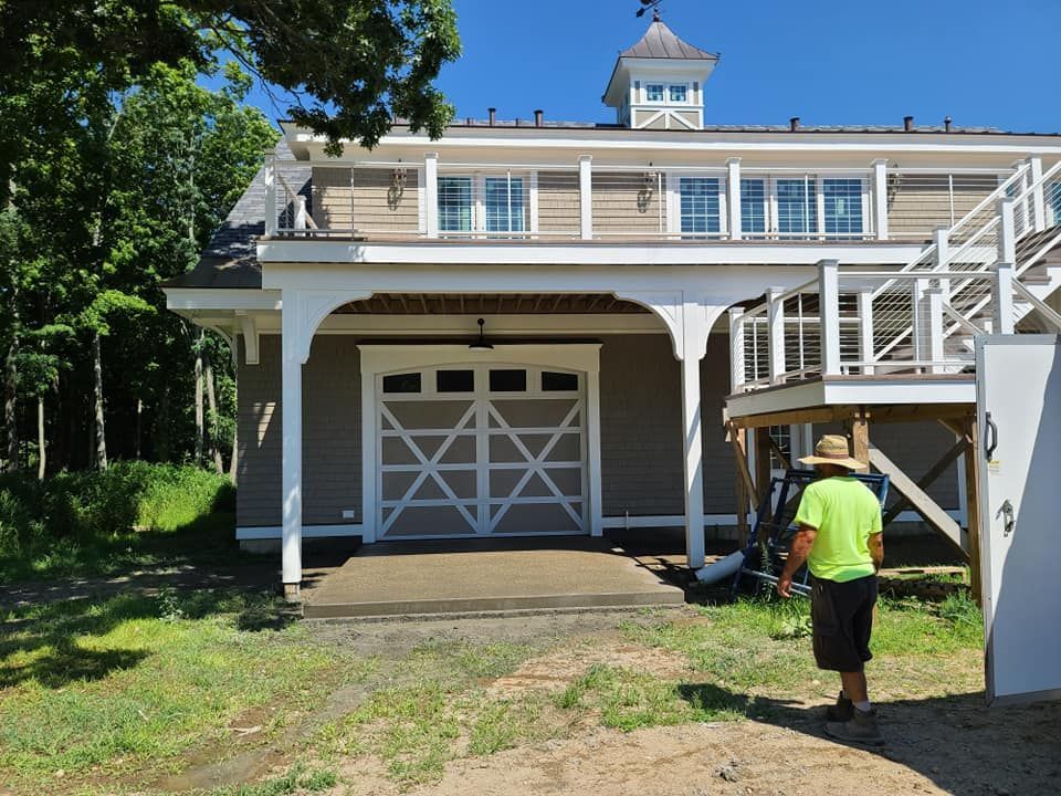 Exterior of a two-story building with a white garage door and a person walking toward it.