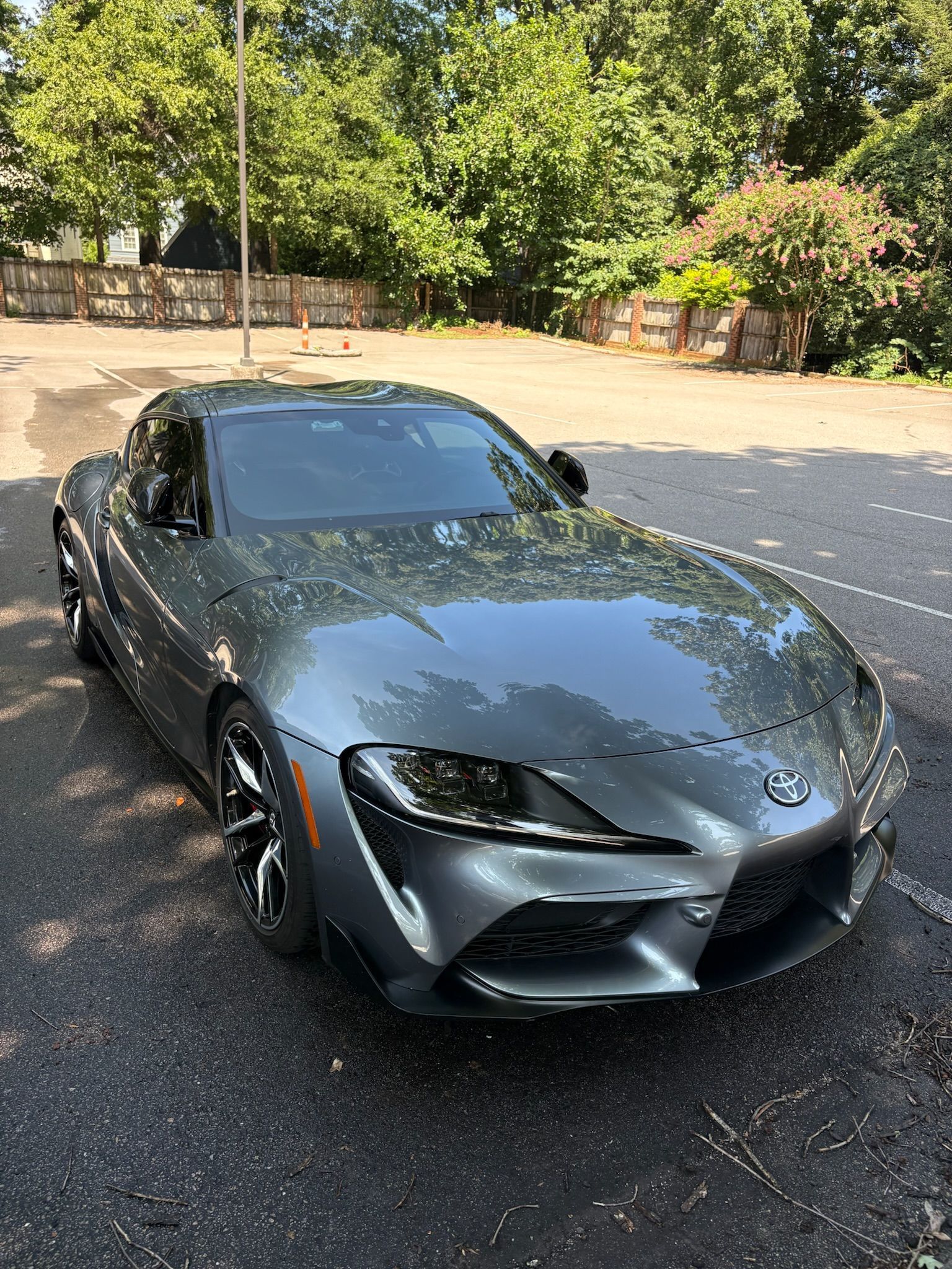 Gray Toyota Supra sports car parked on asphalt.