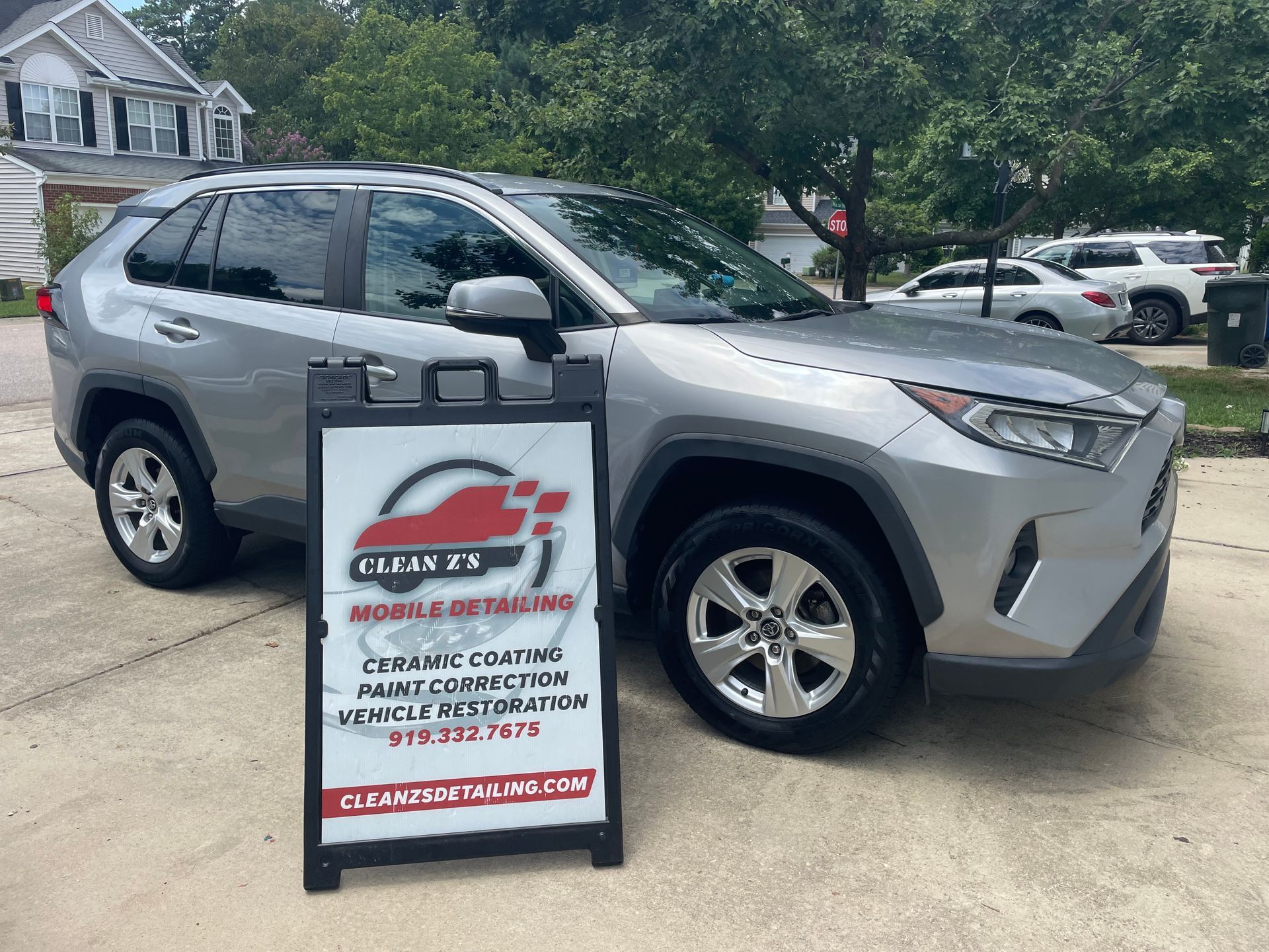 Silver Toyota RAV4 parked in front of an 