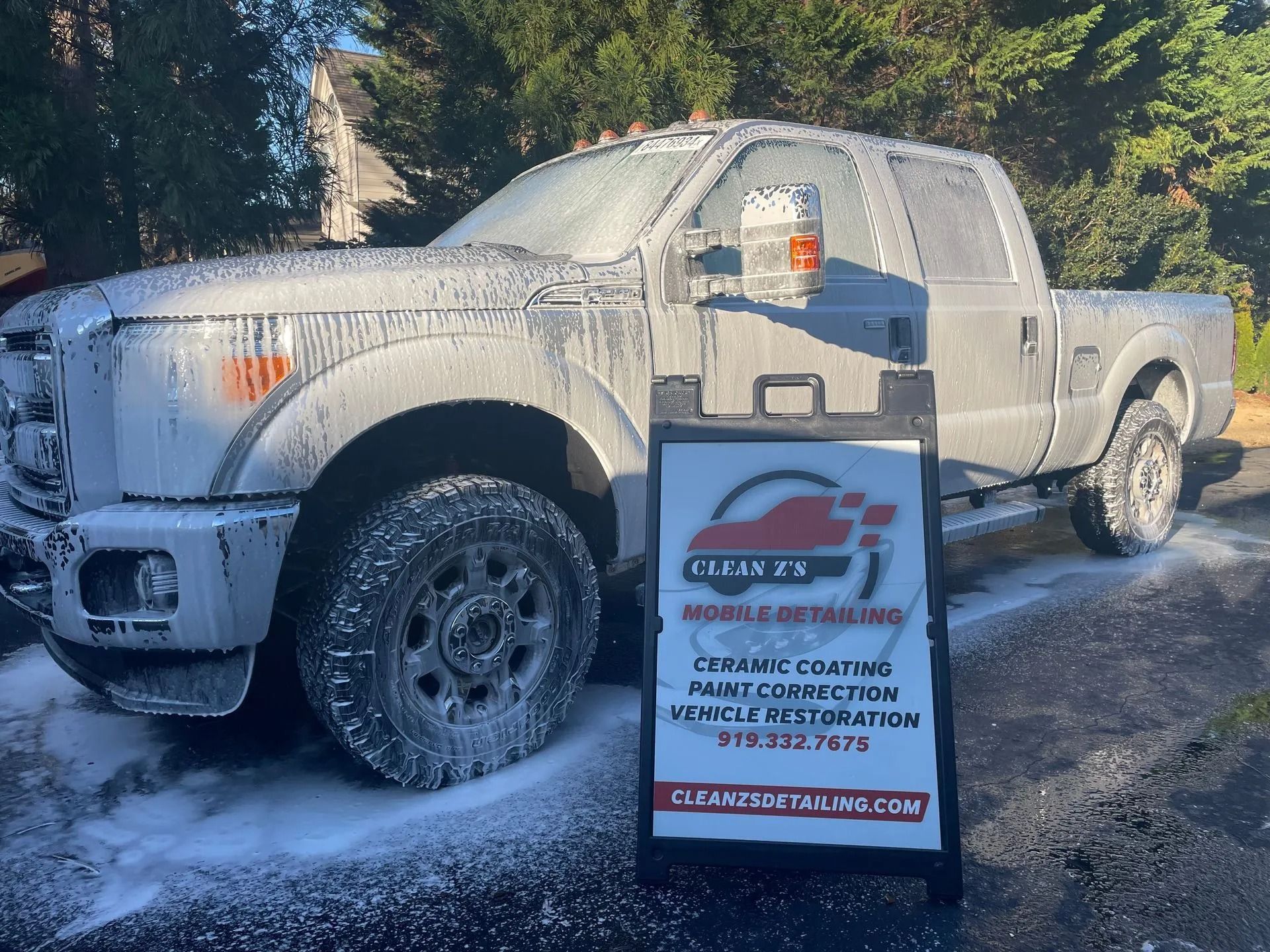 A gray truck covered in soap suds with an 