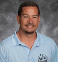 Greg Iker, Man in blue polo shirt smiling, with “Skyline Home Designs” logo.