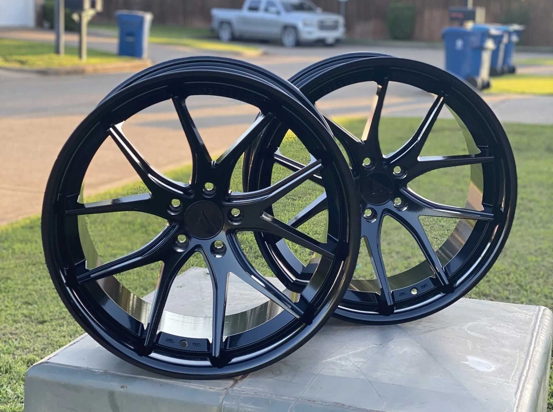 Two glossy black car rims.