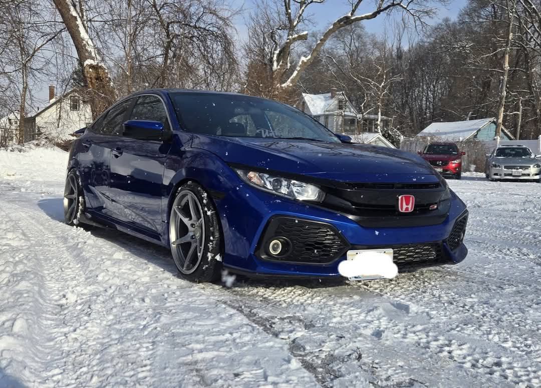 Blue Honda Civic coupe parked in snow, with a red badge.