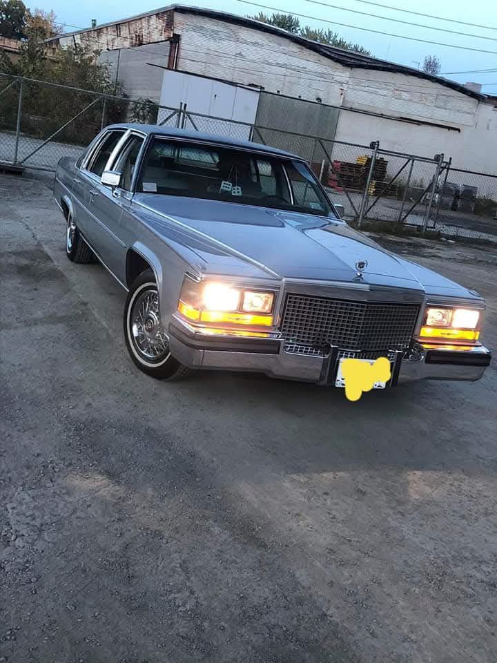 Silver Cadillac sedan parked on asphalt.