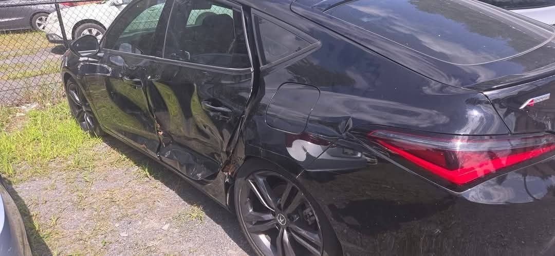 Black car with severe damage to the driver's side doors and rear quarter panel.