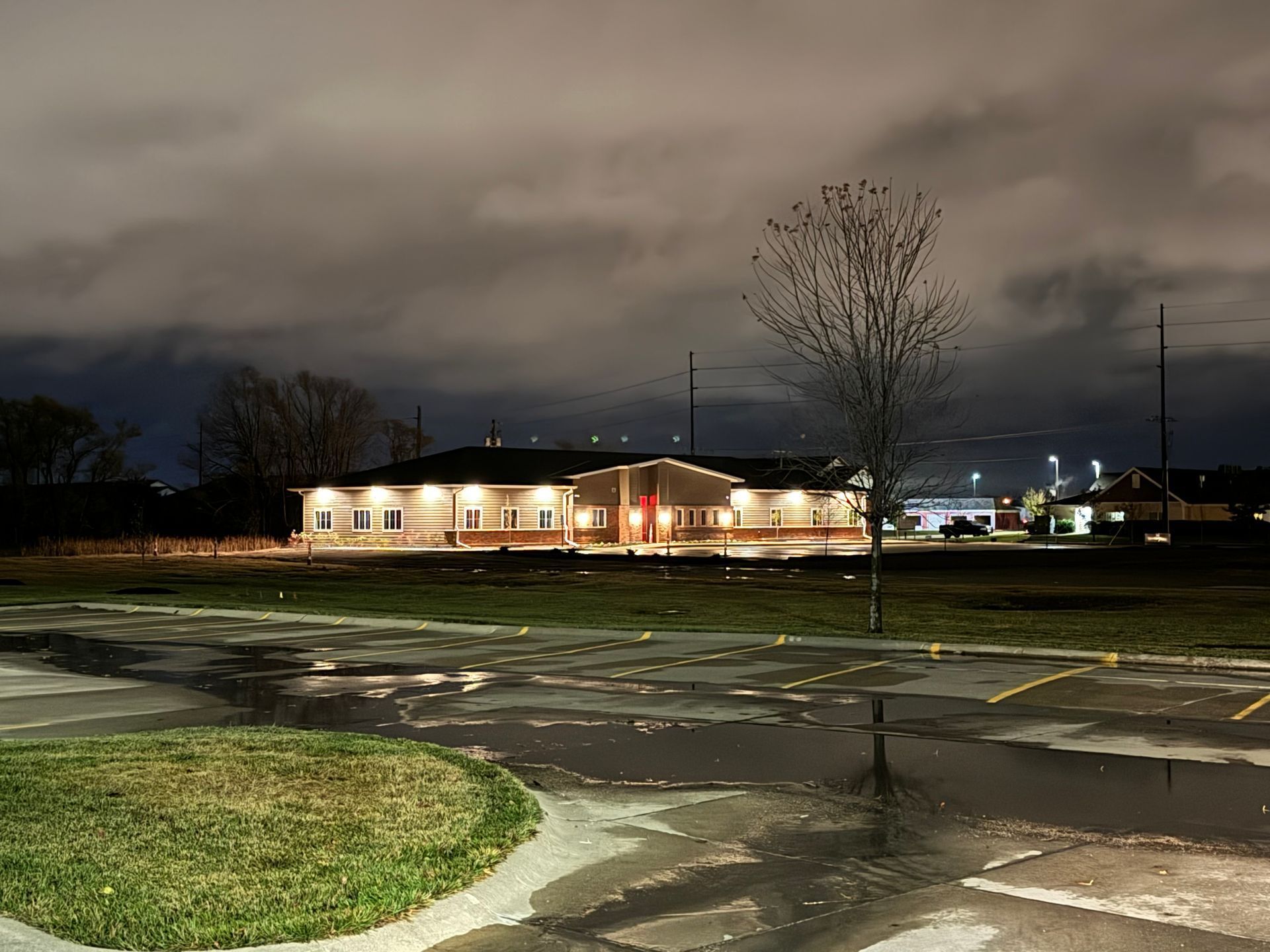 A parking lot with a building in the background at night