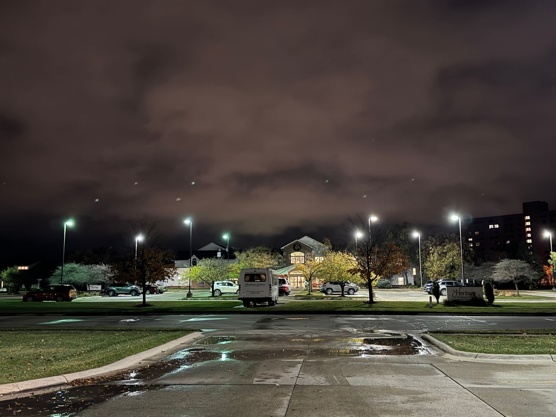 A parking lot at night with a lot of cars parked in it