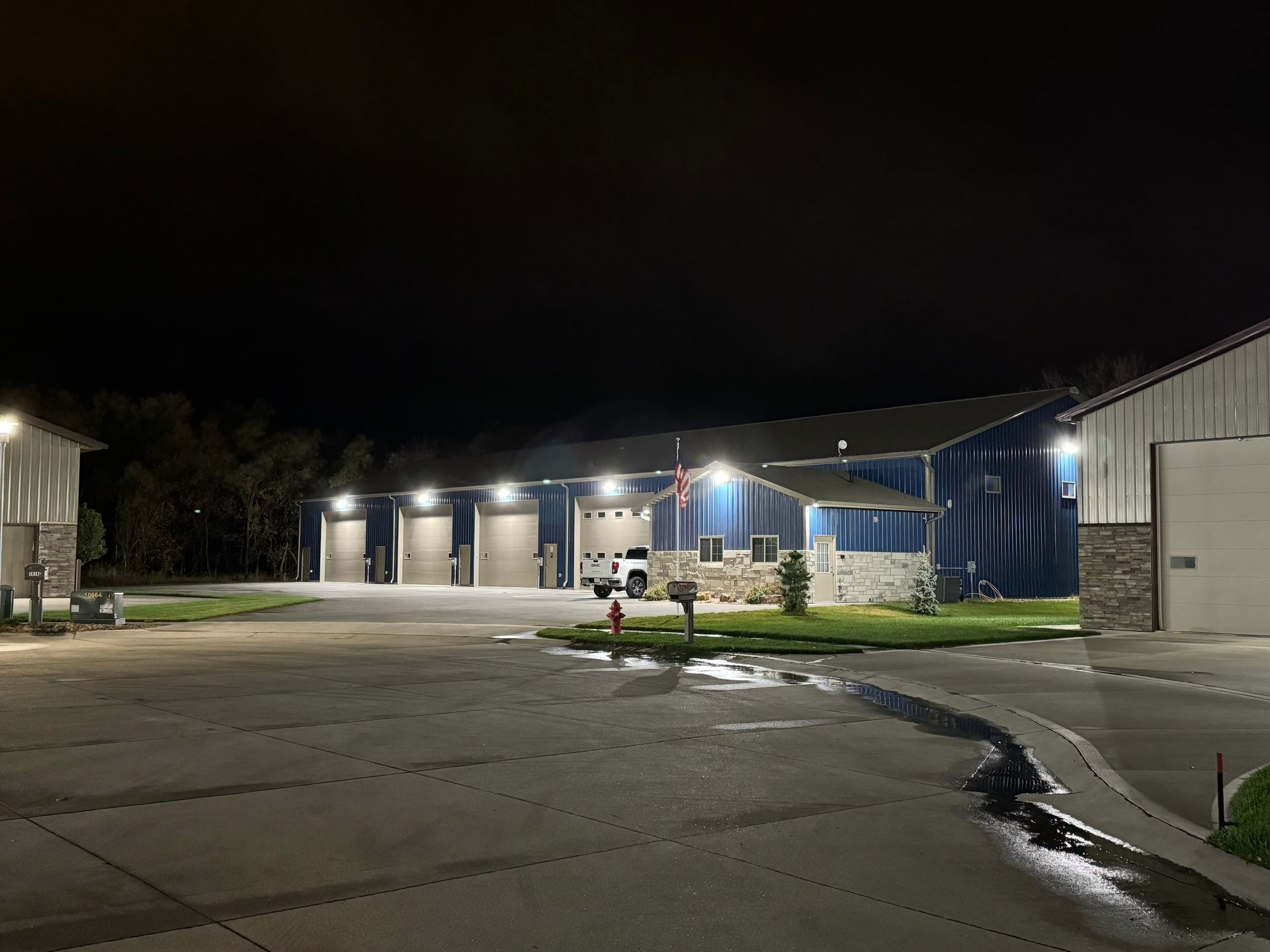 A large building with a lot of garage doors is lit up at night.