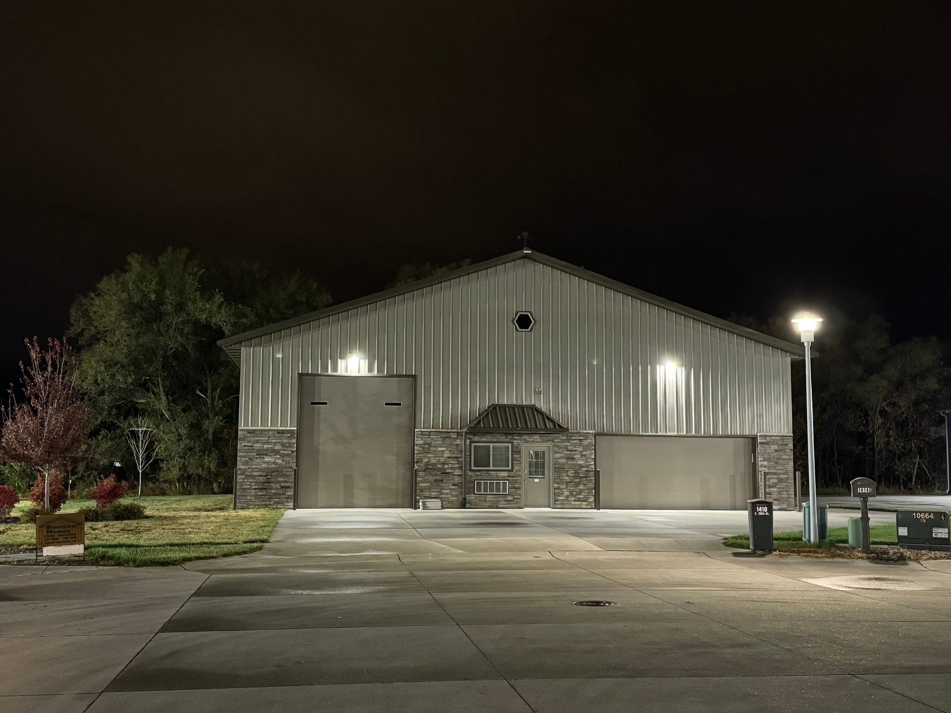 A large building is lit up at night with a parking lot in front of it
