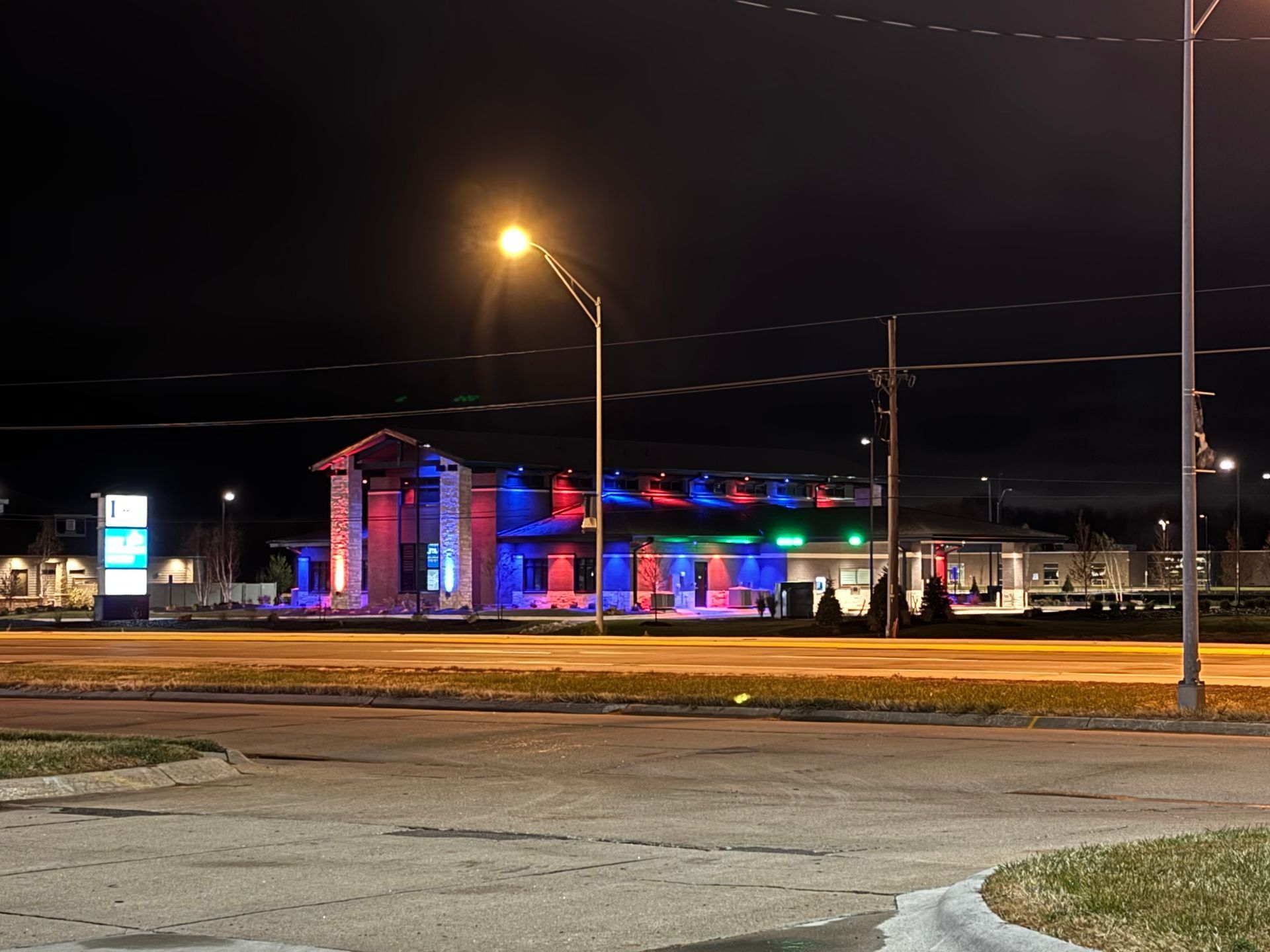A building with red white and blue lights is lit up at night