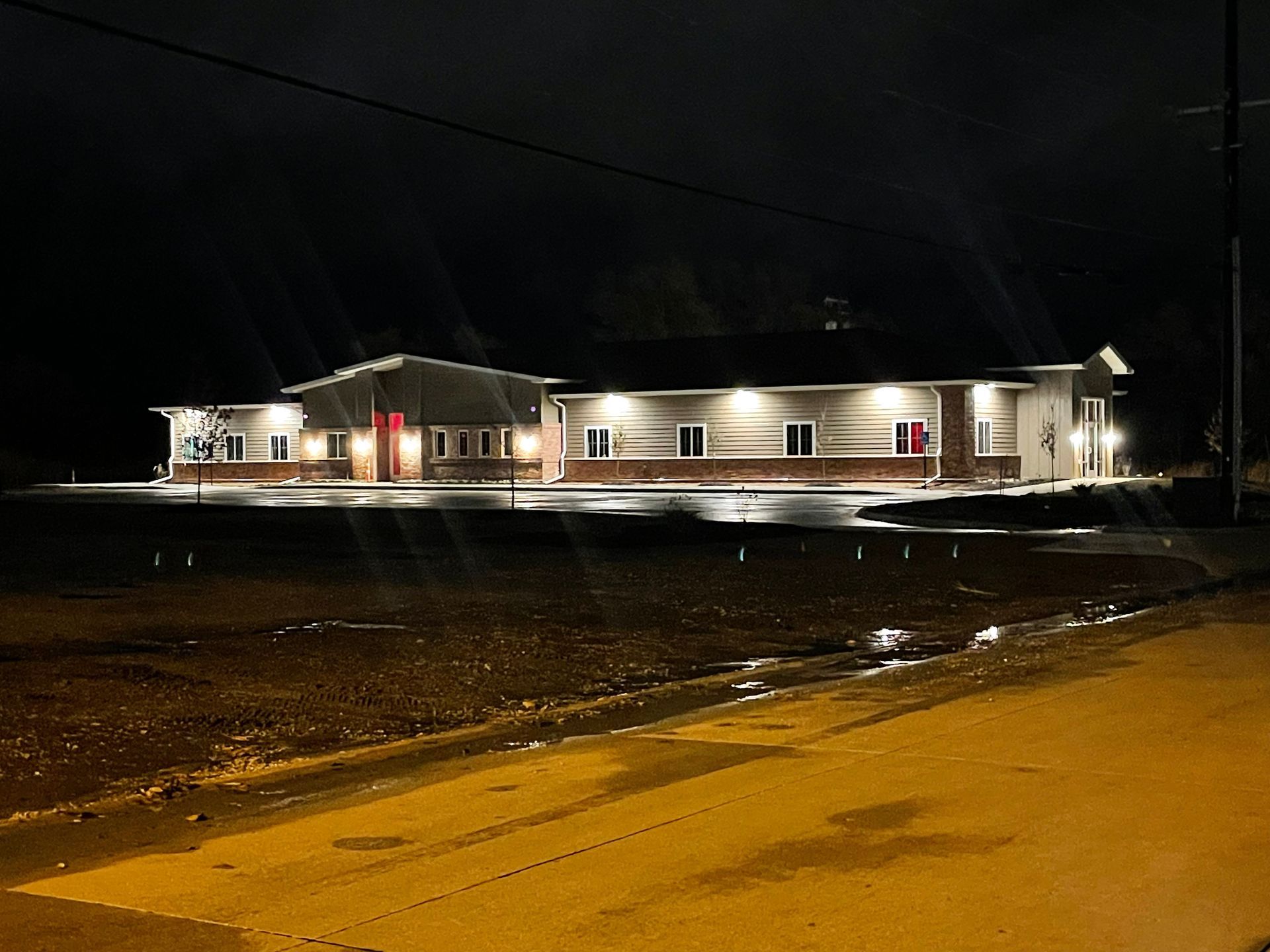 A large white house is lit up at night.