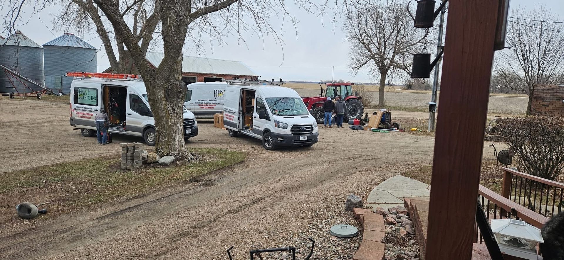 A couple of vans are parked in a dirt field.