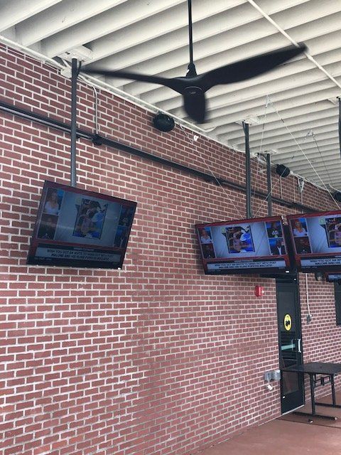 A brick wall with a ceiling fan hanging from it