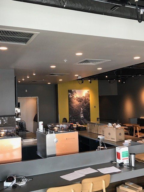 A large room with tables and chairs and a picture on the wall