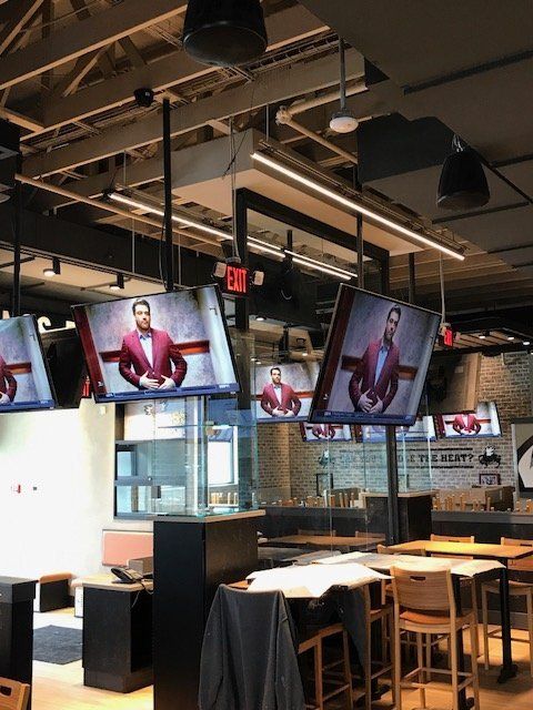 A restaurant with a lot of televisions hanging from the ceiling