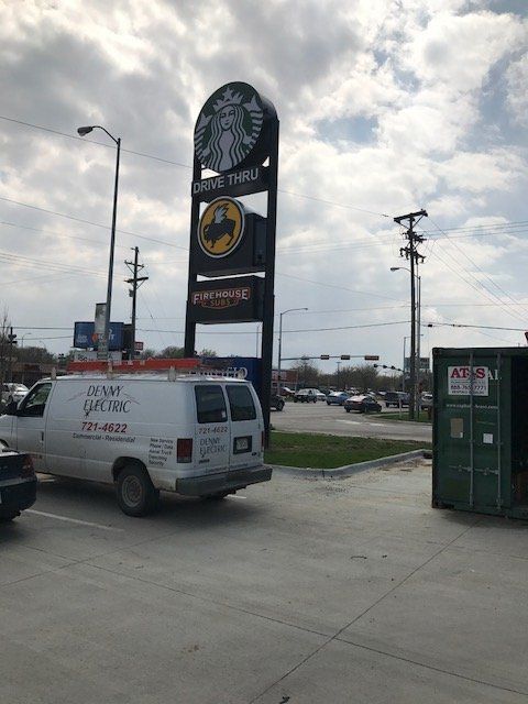 A white van is parked in front of a starbucks sign