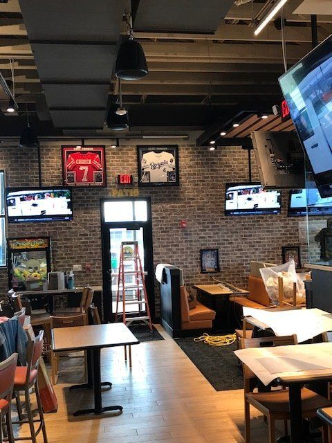 A restaurant with tables and chairs and a scoreboard with the number 7 on it