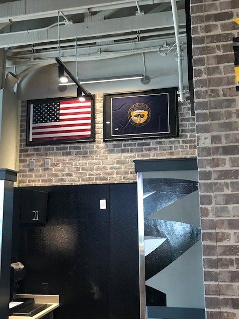 A picture of an american flag hangs on a brick wall