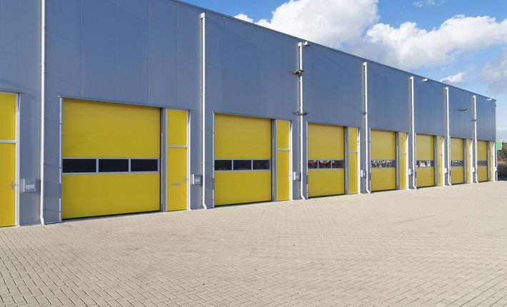 A row of yellow garage doors on a building