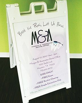 White A-frame sign for Morgan & Associates Dental Office, offering free dental services for kids.