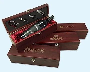 Wine bottle in a wooden box with opener accessories, three other closed branded boxes.