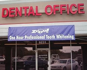 Dental office with a banner advertising one-hour professional tooth whitening; red sign, blue banner.