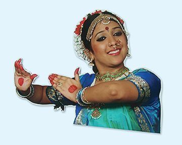 Indian dancer in traditional attire with hands posed, smiling.