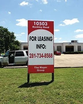 Sign for leasing, 10503 Rockley Road, with contact info and a red and white design, in front of a building and SUV.