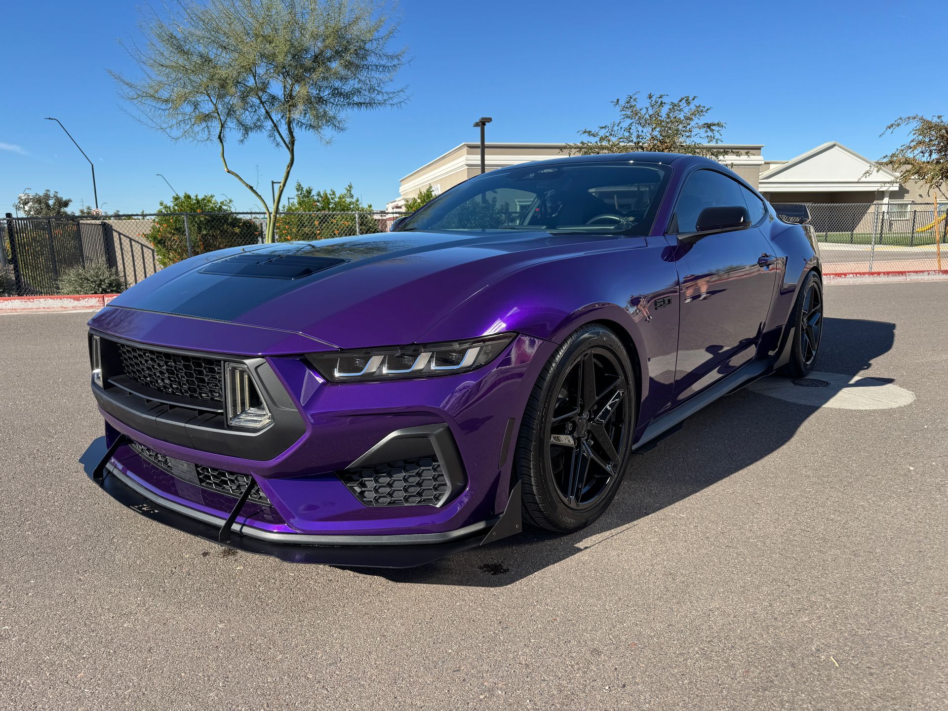 Purple sports coupe parked on a sunny street, shown from the front-left angle.