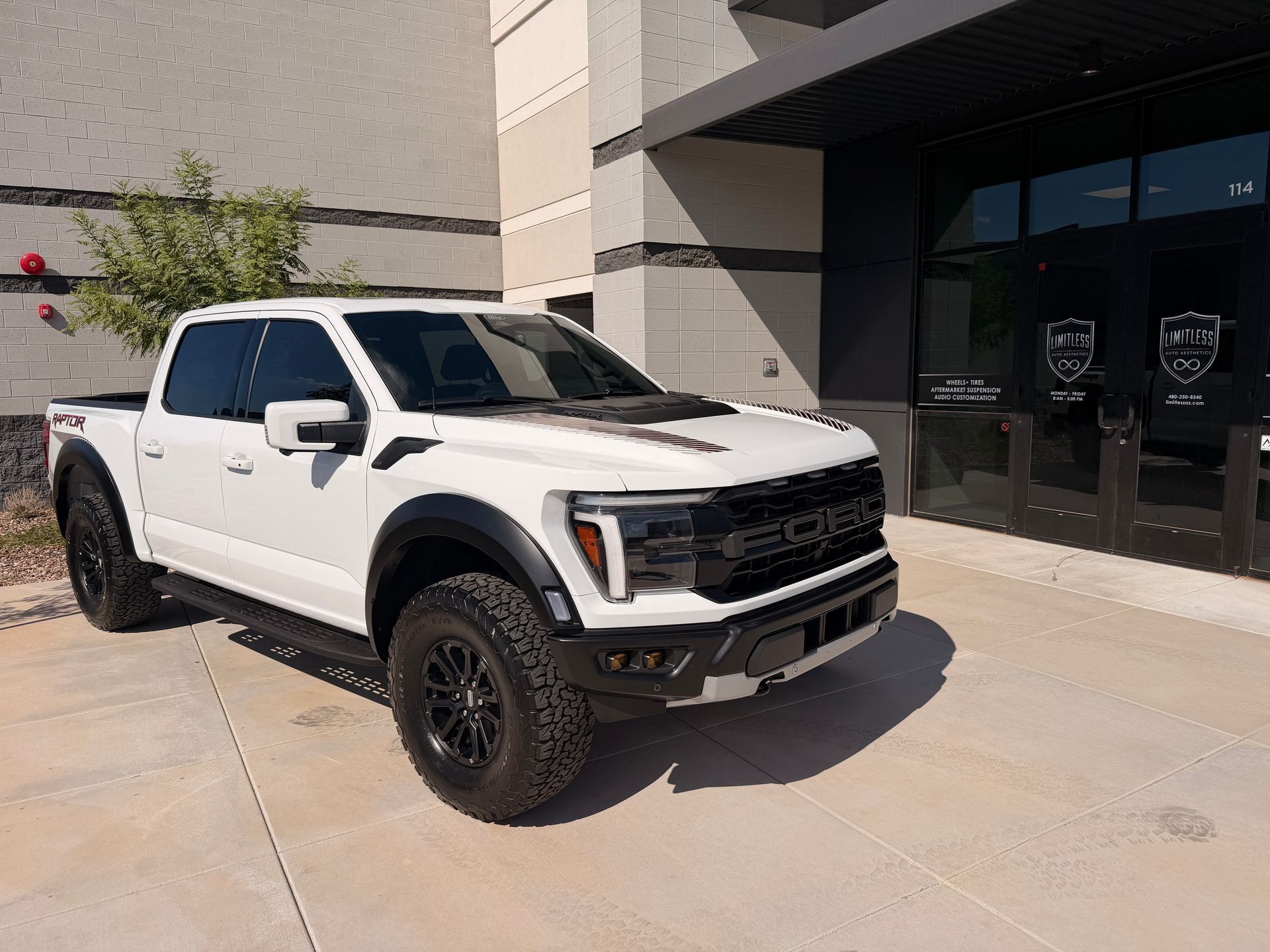 A white pickup truck parked outside a building entrance.