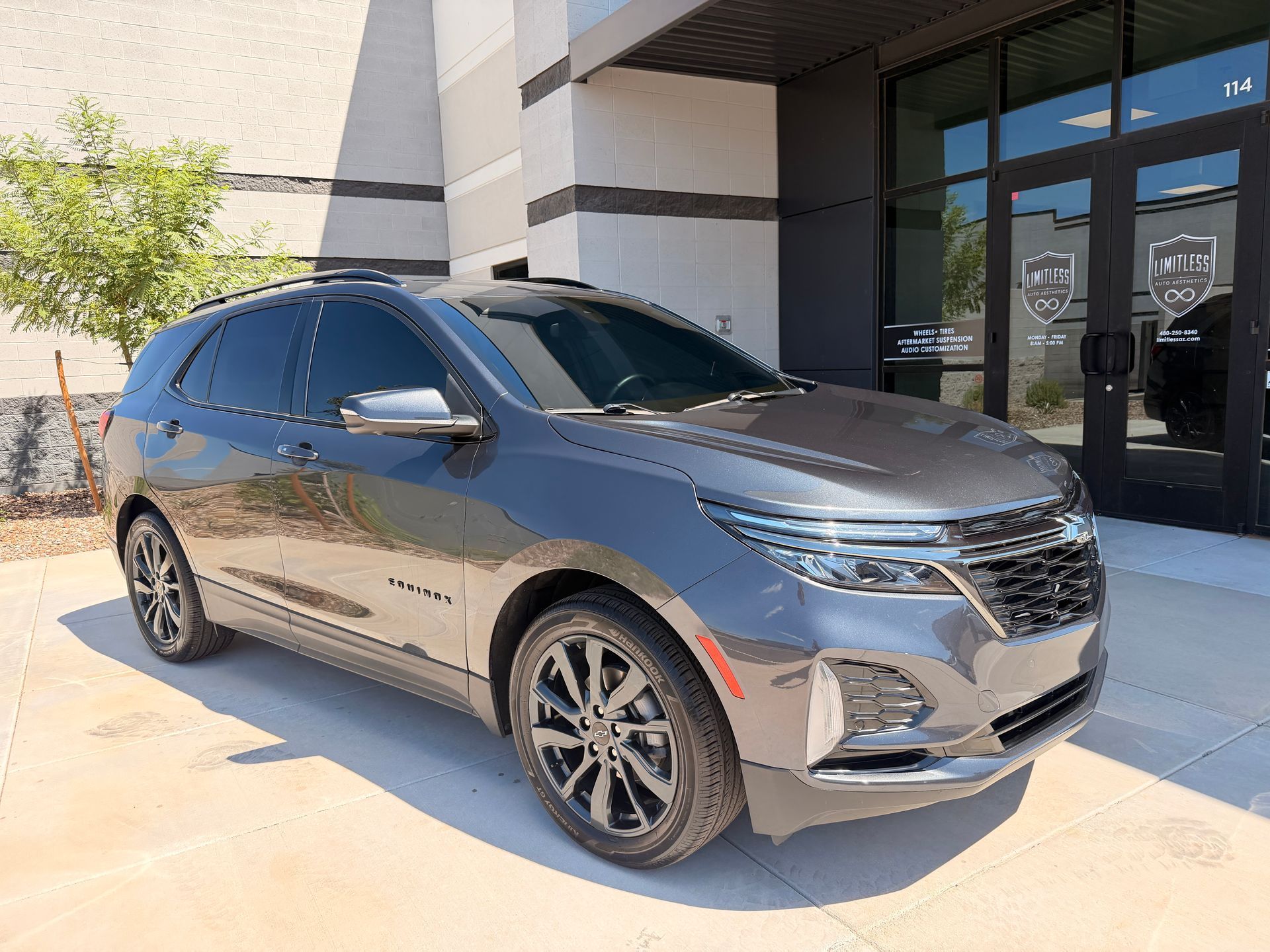 Gray SUV parked outside a building entrance in bright sunlight