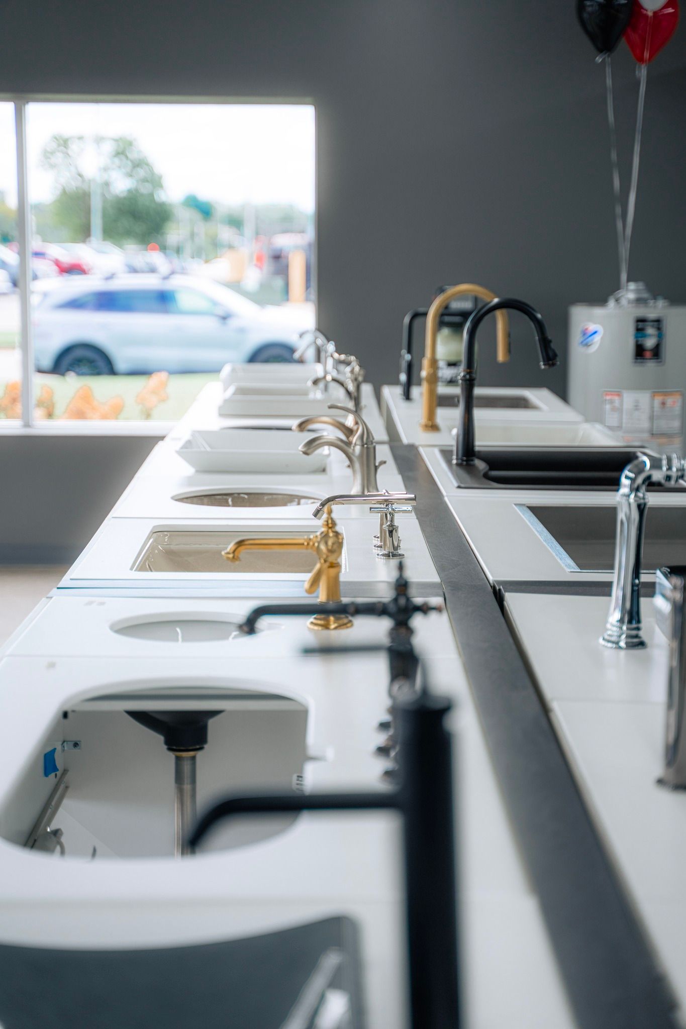 A row of sinks and faucets in a kitchen showroom.