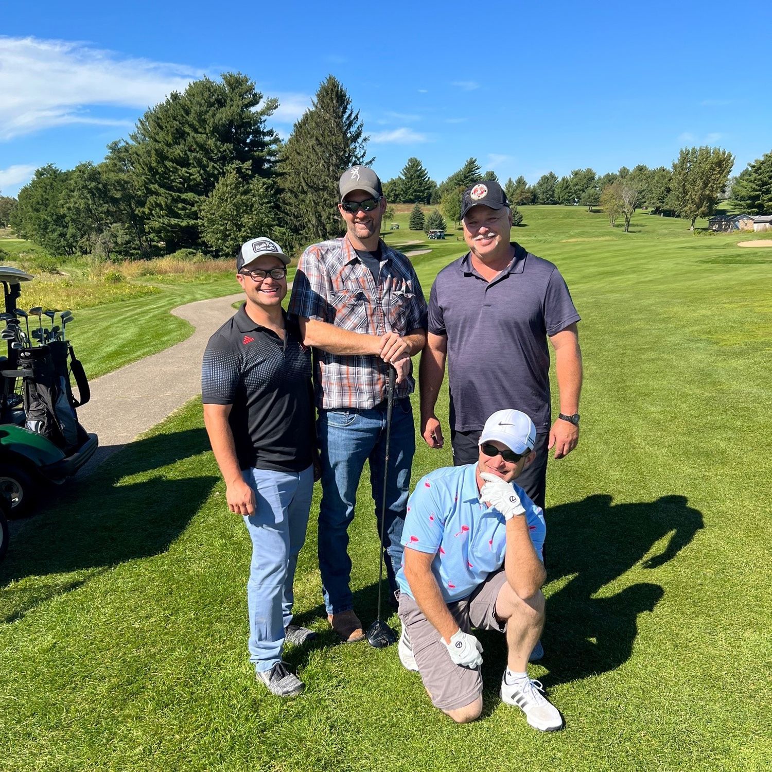 A group of men are posing for a picture on a golf course.