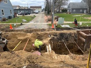 Construction site with a worker in a trench near a street