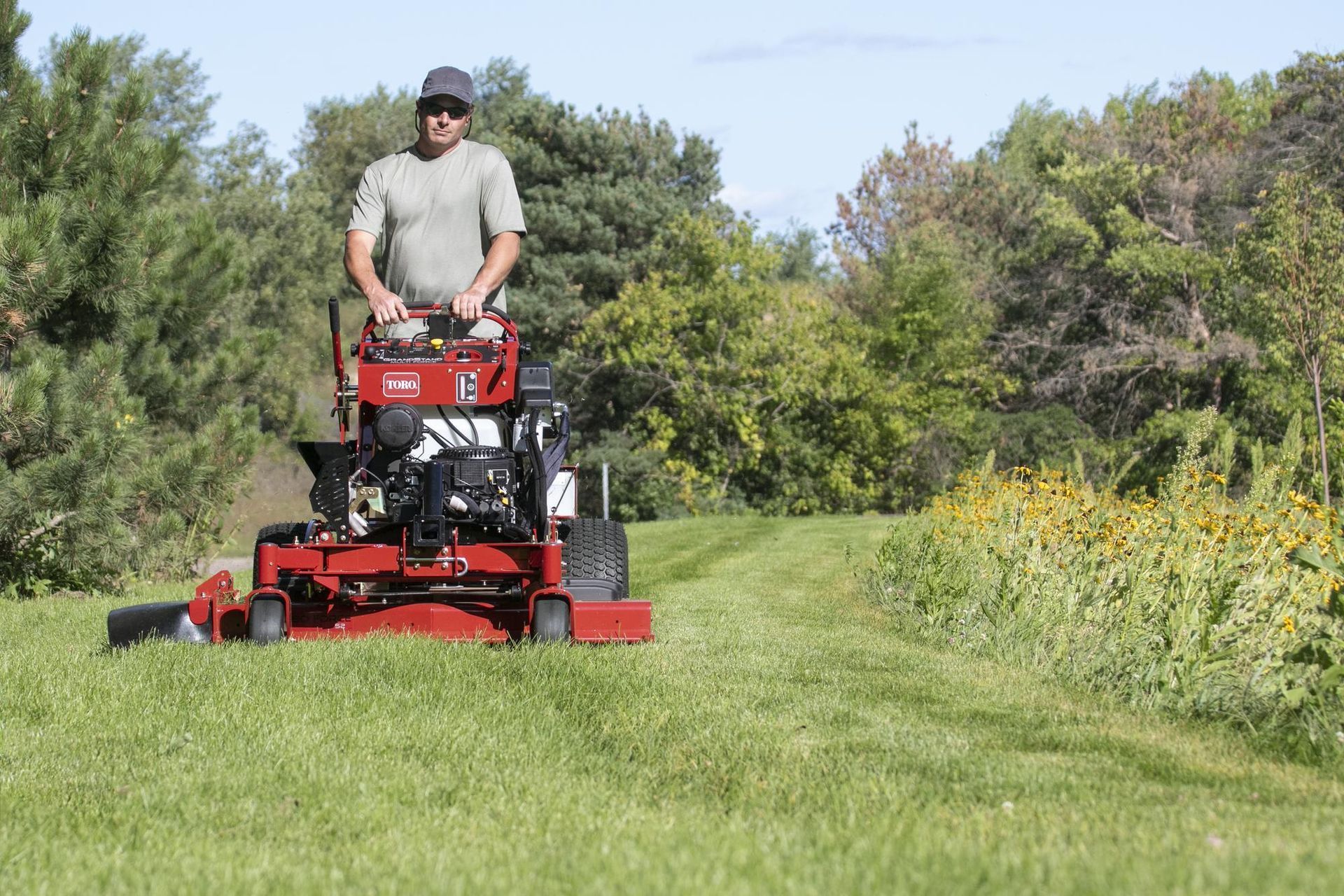 a man is riding a lawn mower through a grassy field .