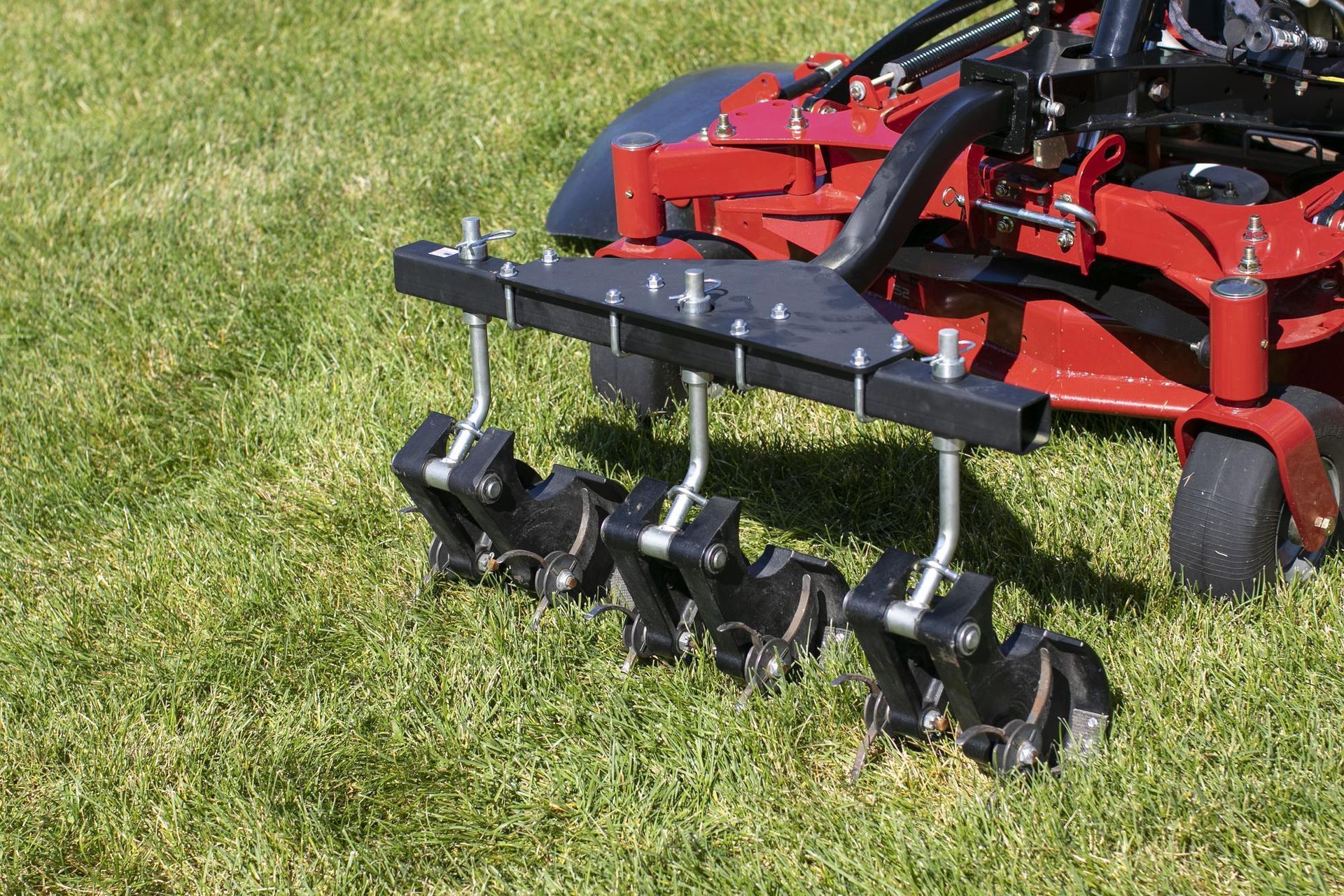 a red lawn mower is sitting on top of a lush green lawn .