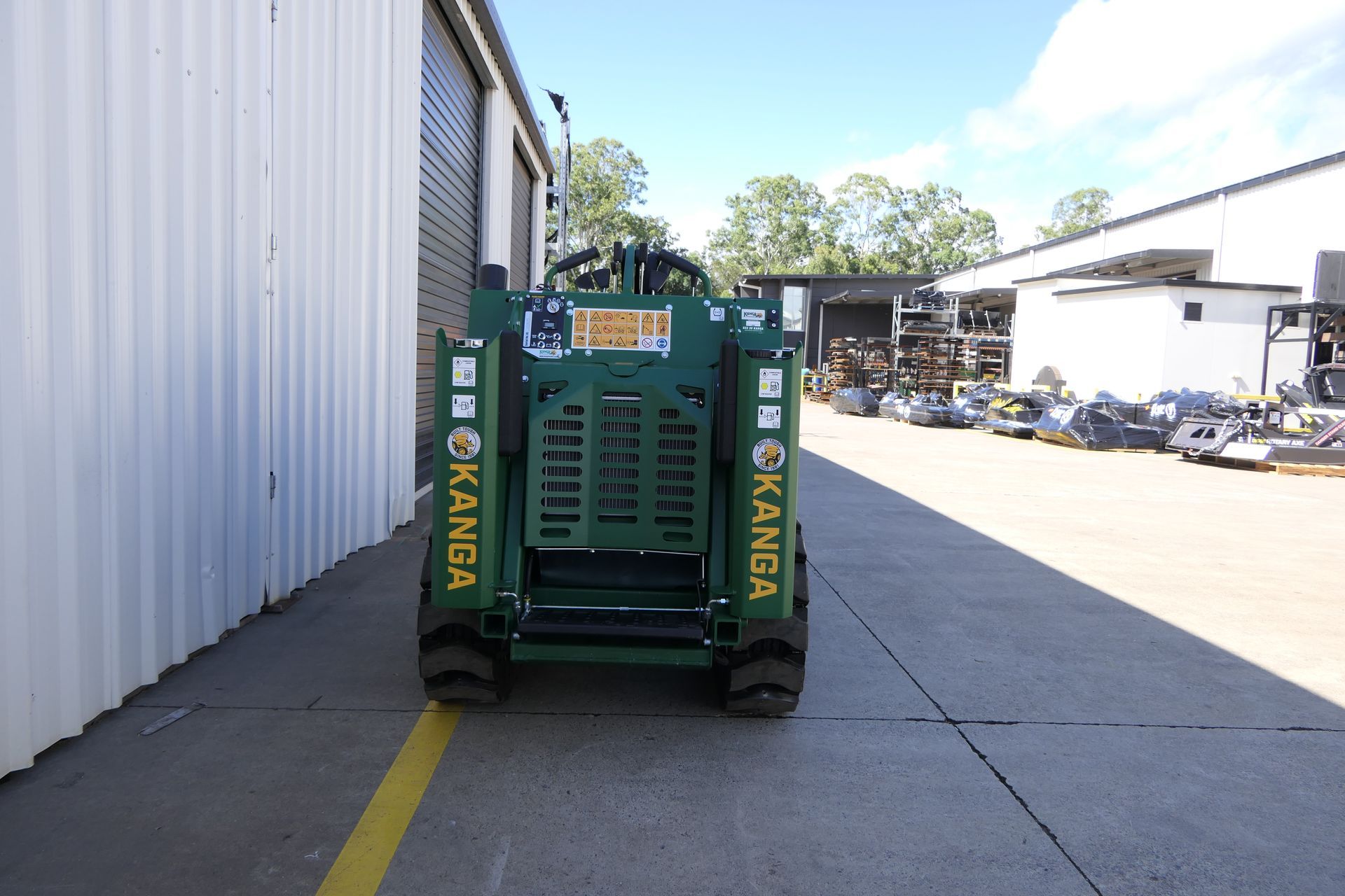 A green dingo is parked in front of a building