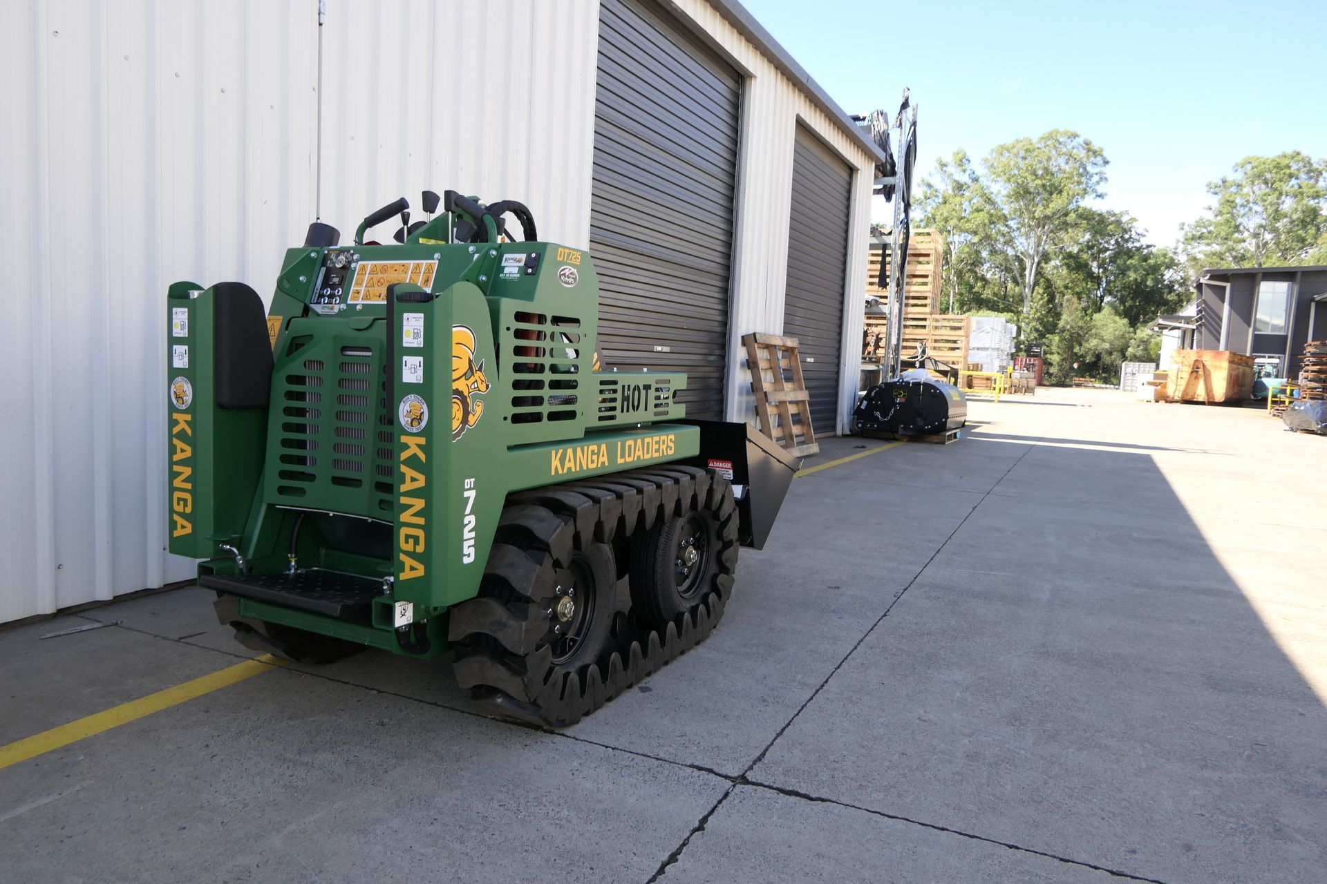 A green dingo is parked in front of a building.
