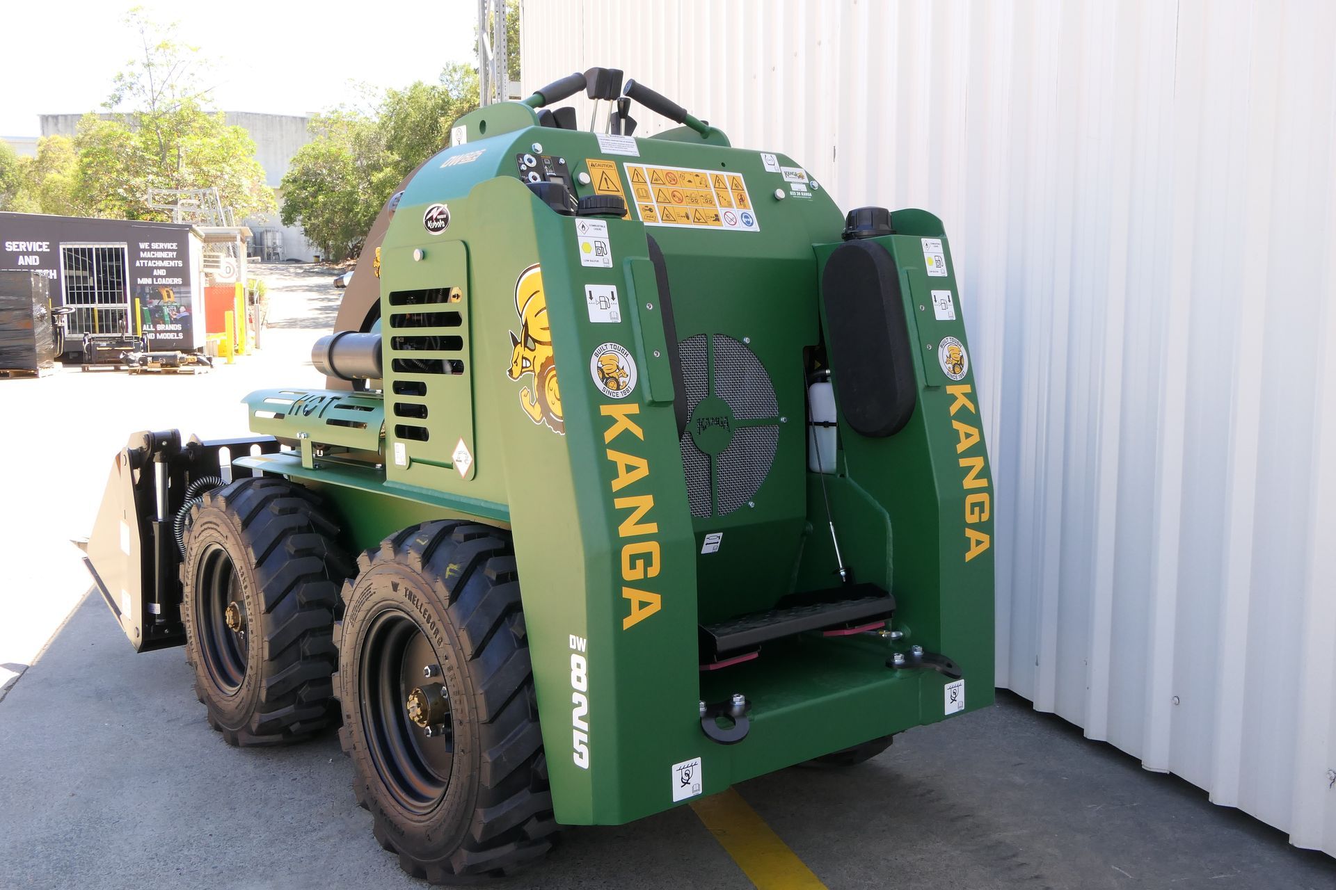 A green Kanga tractor is parked in a parking lot