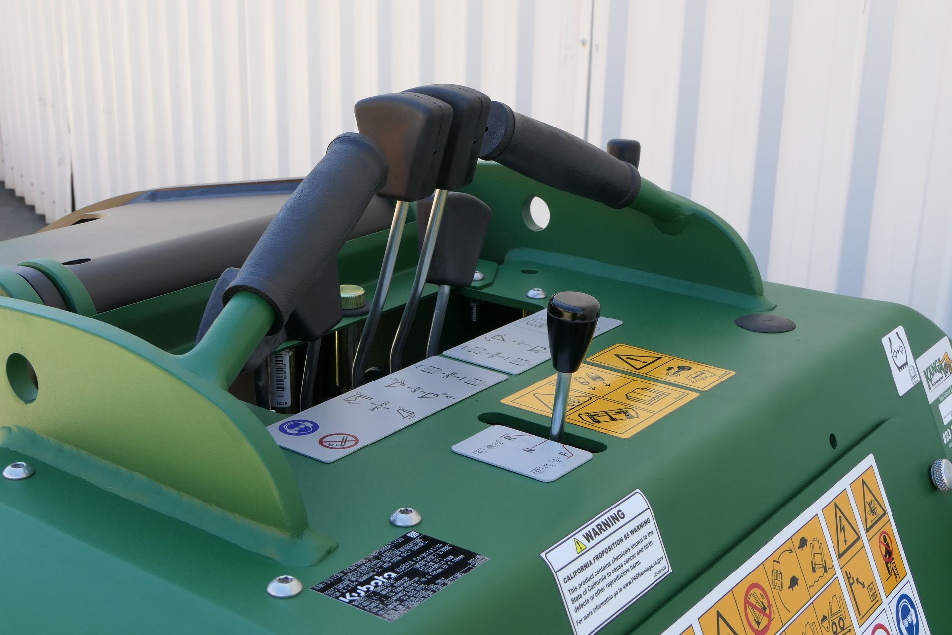 A green Kanga tractor with a steering wheel and controls