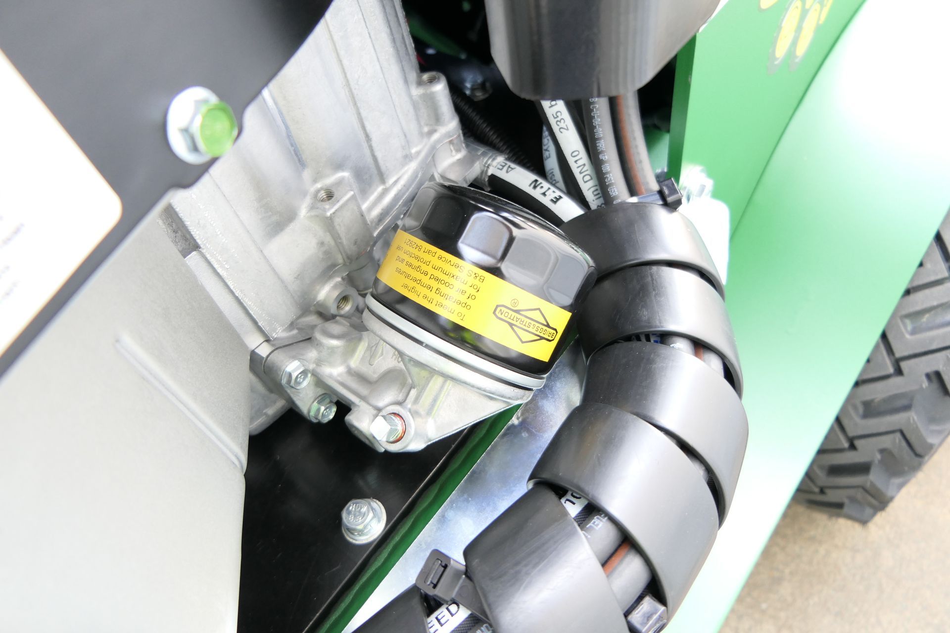 A close up of a tractor engine with a oil filter on it