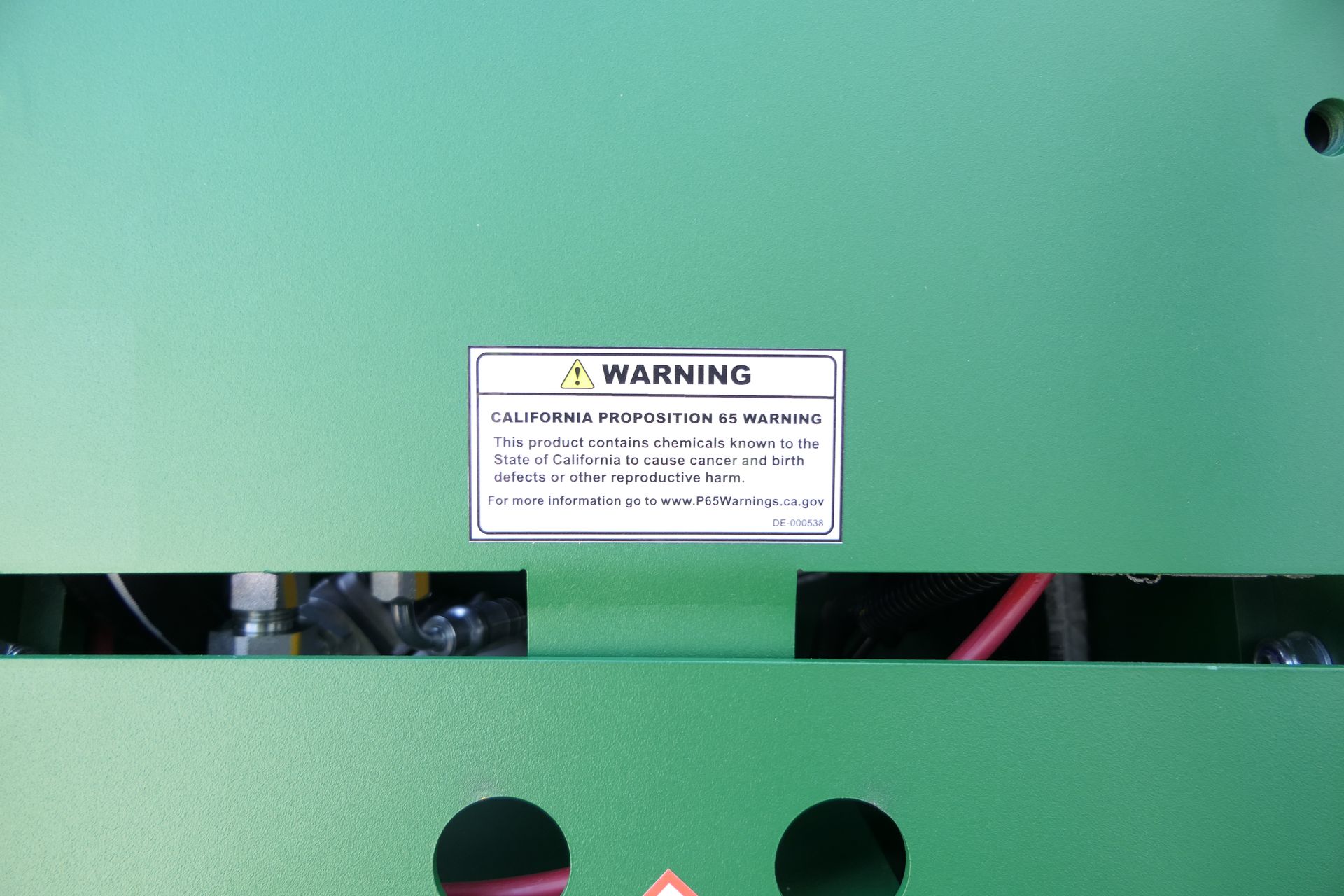 A green machine with a warning sign on it.
