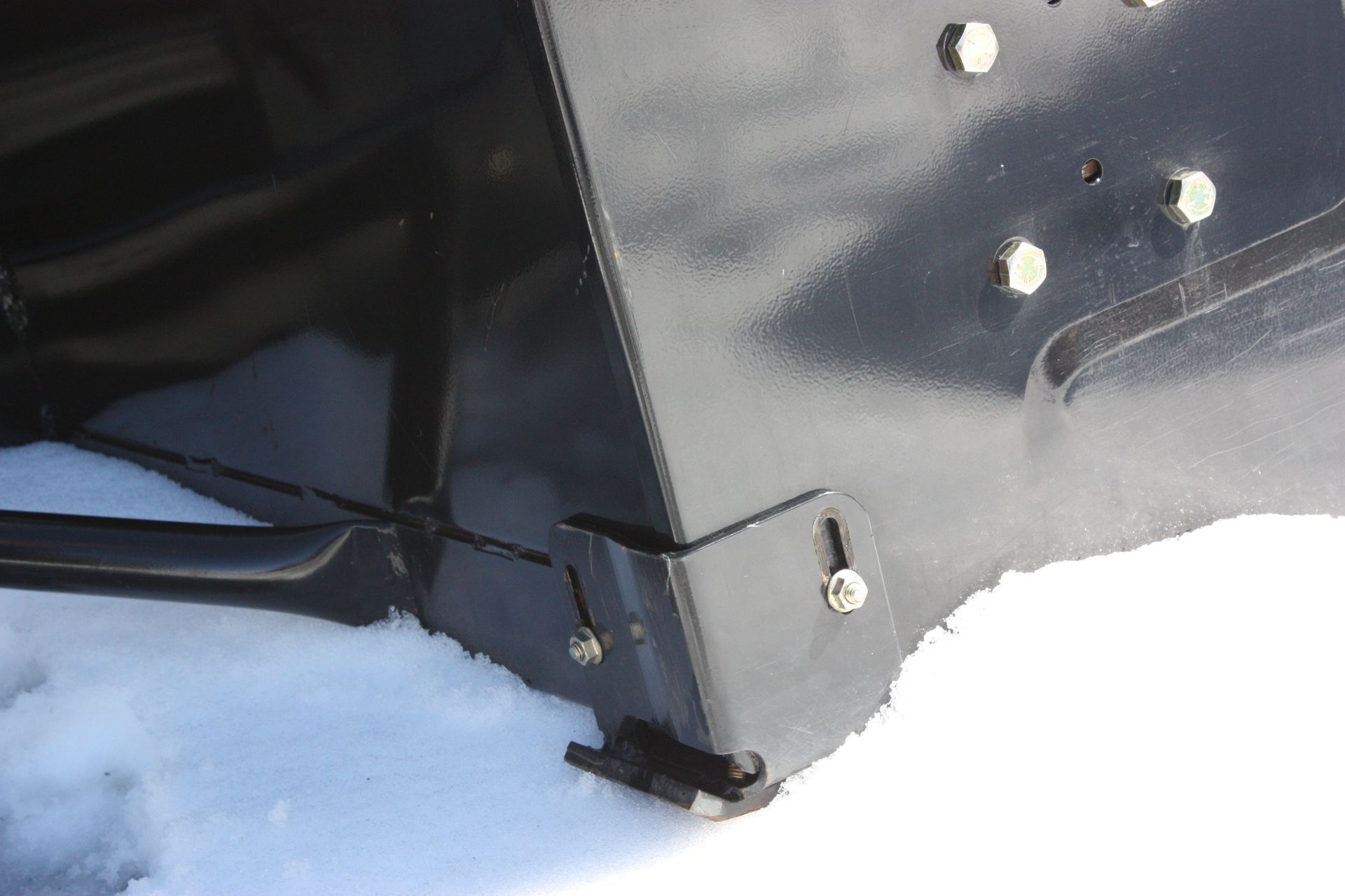 A close up of a snow plow in the snow.