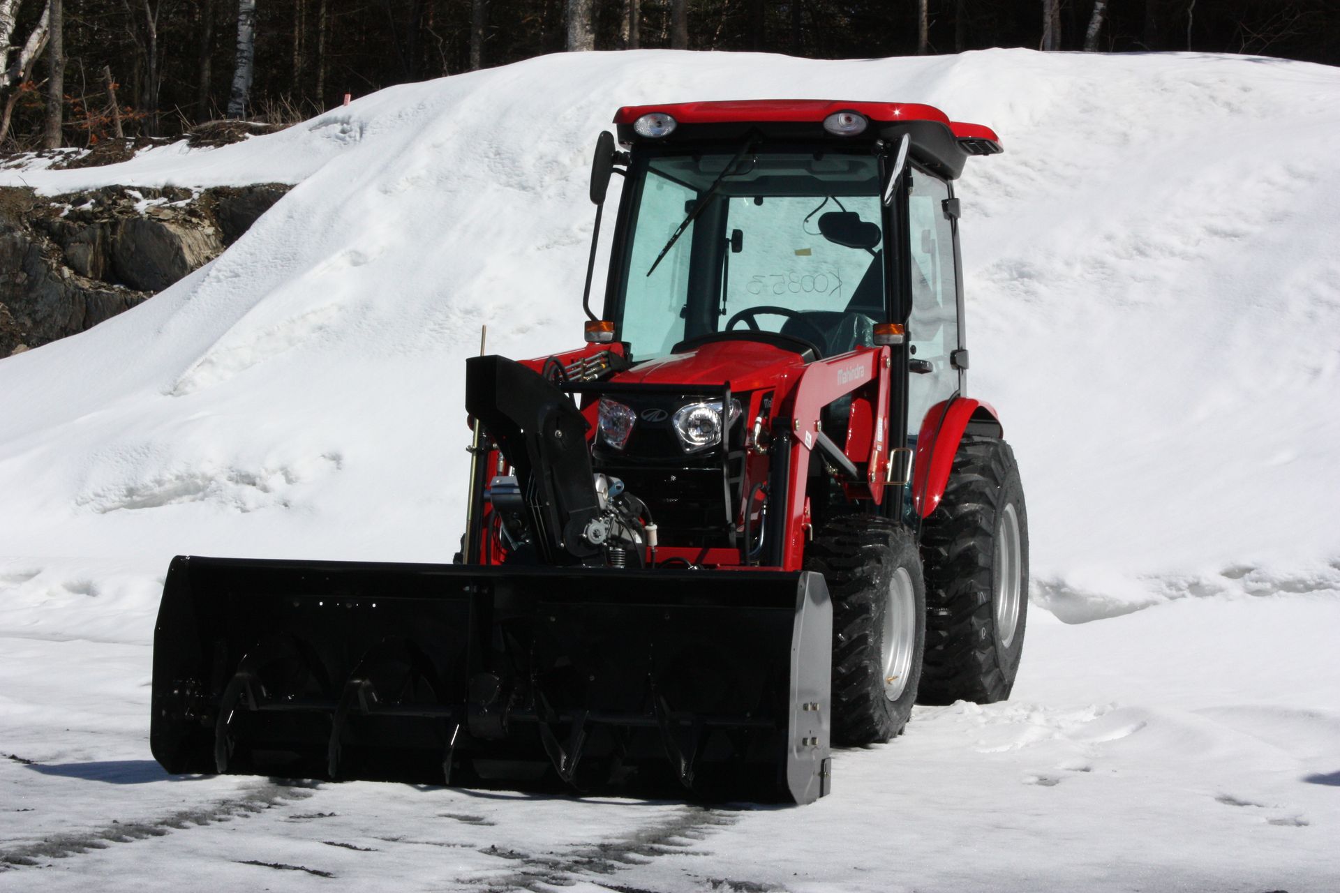 A red tractor with a snow plow 66″ VANTAGE SNOWBLOWER FOR TRACTORS EQUIPPED WITH