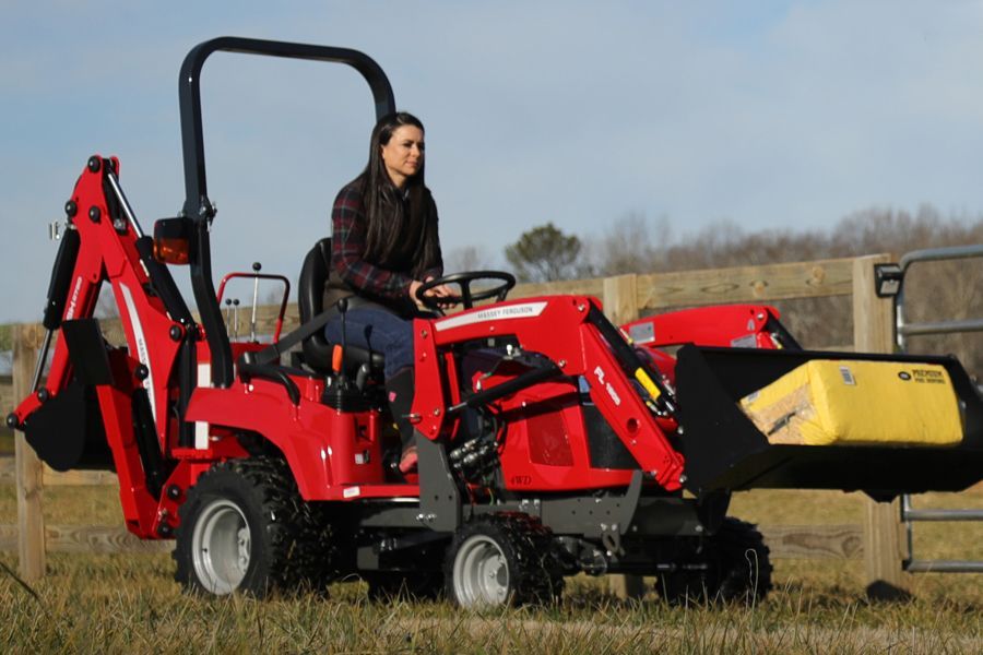Woman riding a tractor with a backhoe