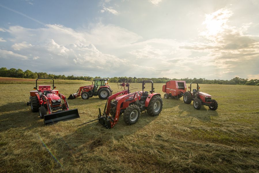A group of tractors are parked in a field